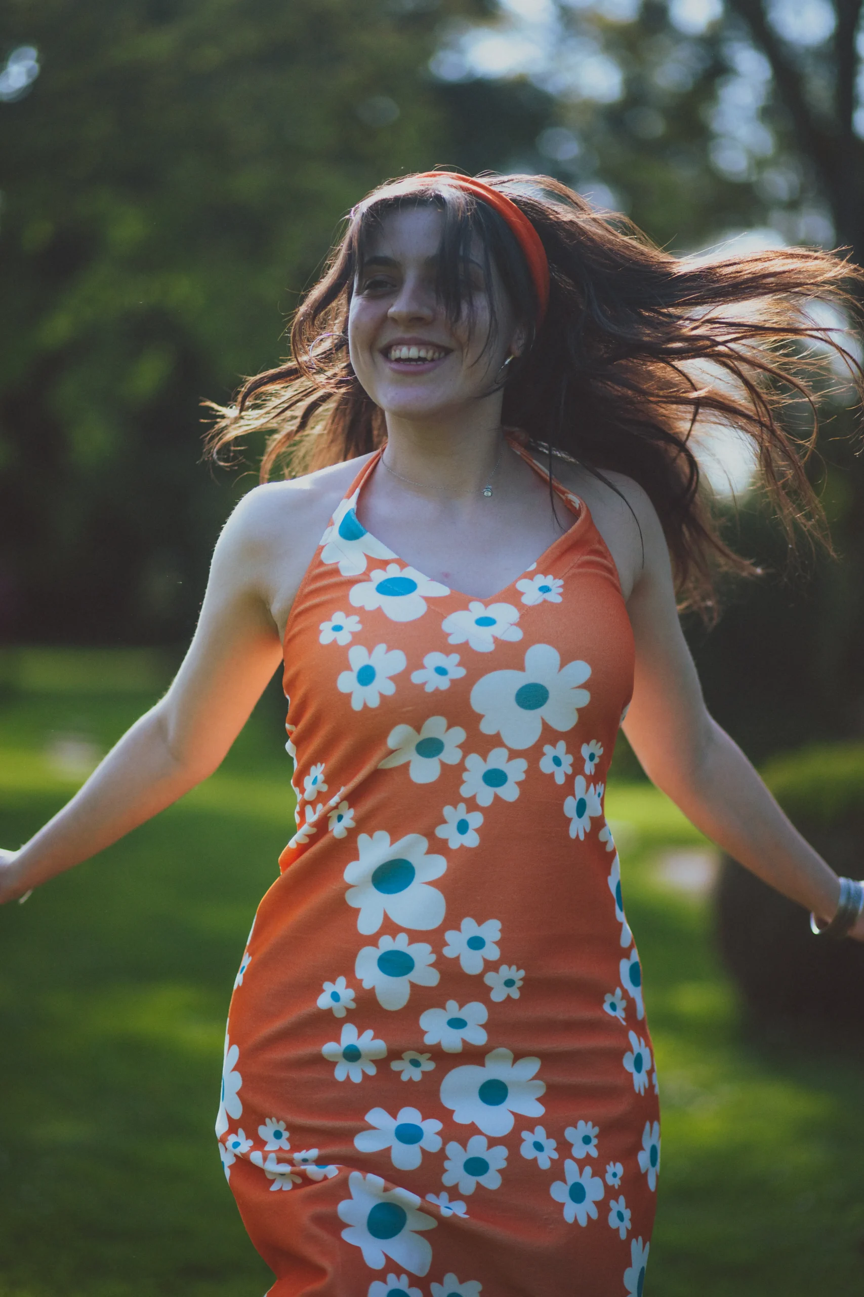 Une jeune femme en robe orange qui danse